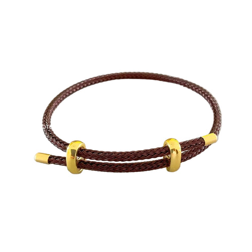 Brown braided bracelet with gold accents on a light gray background