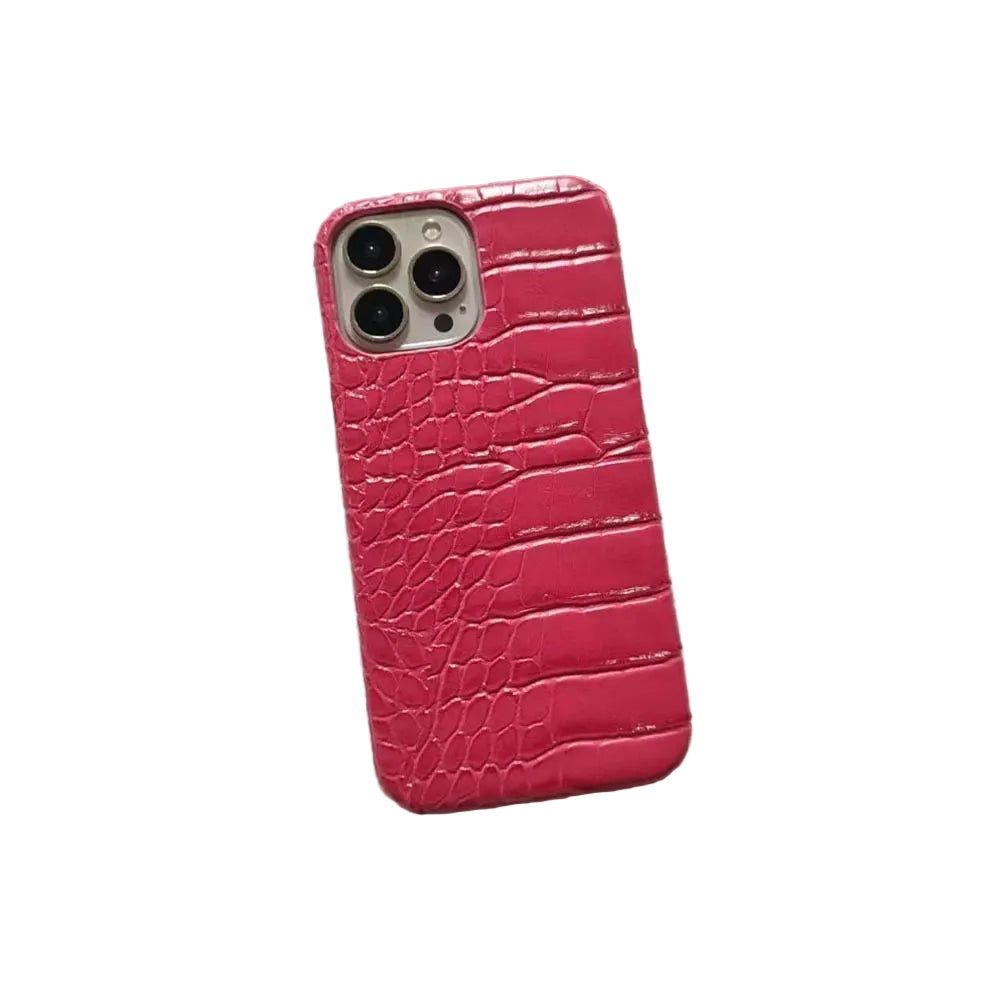 Pink crocodile texture phone case on a textured surface with text in the background